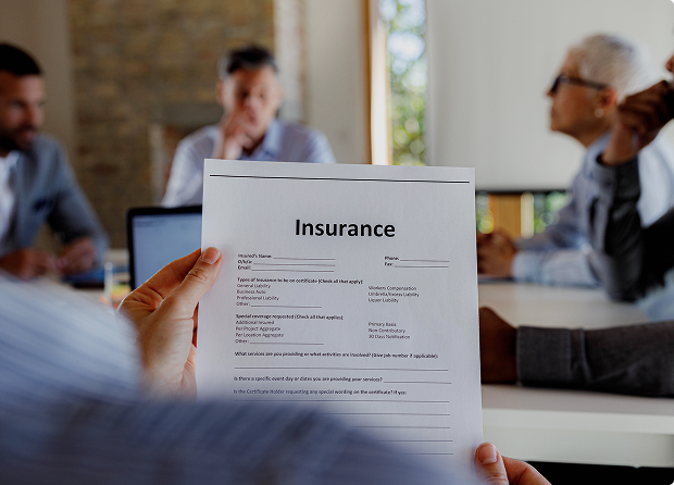 Person holding insurance document in meeting.