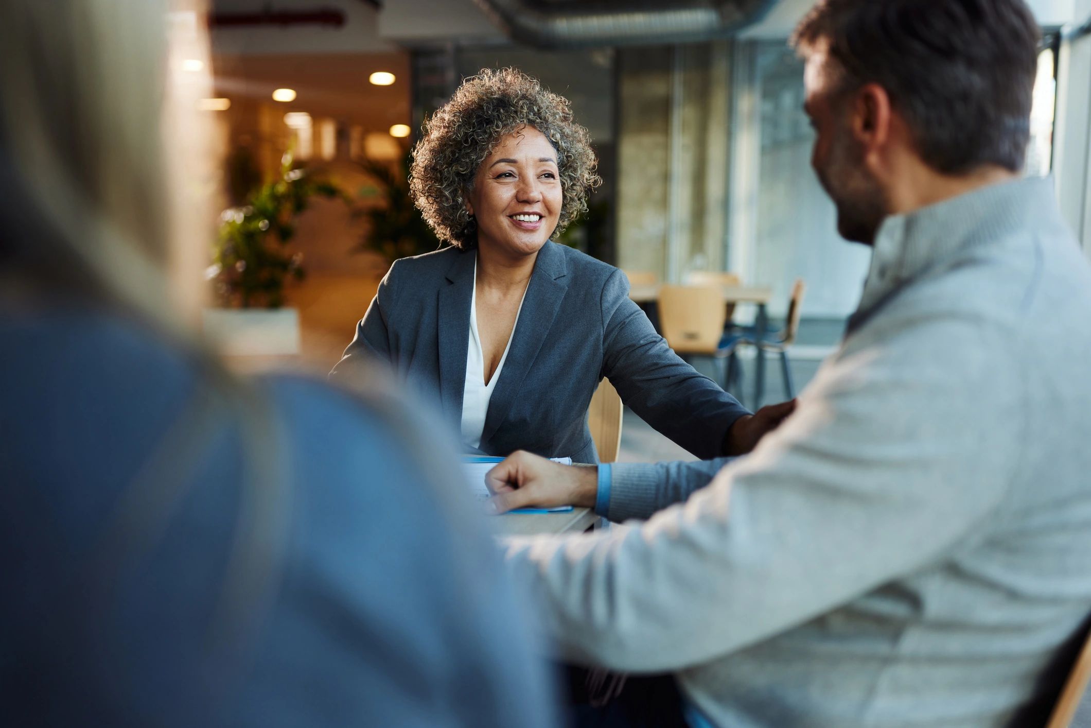 Insurance agent speaking with clients across a desk