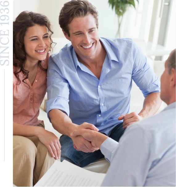 Smiling couple shaking hands with advisor