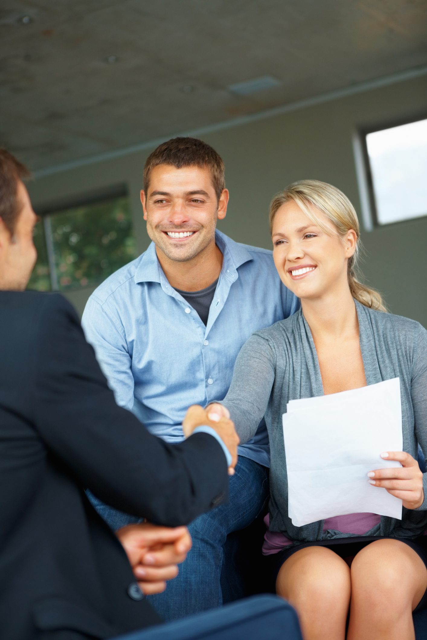 Smiling couple shaking hands across table