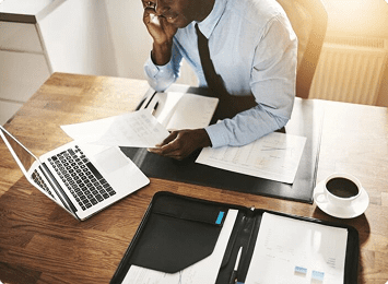 Man working at desk with laptop.