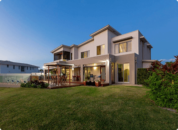Modern house with garden at sunset.