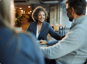 Business meeting with three people conversing happily.